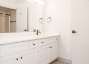 Thumbnail 9 of 42 - a bathroom with white cabinets and a sink and a mirror