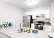 Thumbnail 14 of 25 - a kitchen with white cabinetry and stainless steel appliances