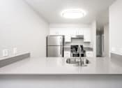 Thumbnail 19 of 25 - a kitchen with white countertops and a stainless steel refrigerator