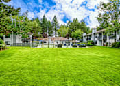 Thumbnail 7 of 25 - a large grassy area with houses in the background