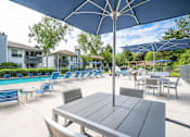 Thumbnail 2 of 25 - the reserve at bucklin hill leasing office patio with tables and chairs and umbrellas