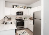 Thumbnail 2 of 42 - a kitchen with stainless steel appliances and white cabinets