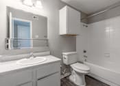 Thumbnail 13 of 46 - A white bathroom with a toilet, sink, and bathtub.