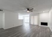 Thumbnail 6 of 46 - A spacious living room with a fireplace and a ceiling fan.
