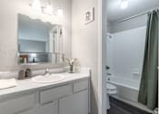 Thumbnail 14 of 46 - A bathroom with a white sink and a mirror above it.