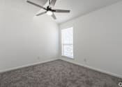 Thumbnail 43 of 46 - A room with a ceiling fan and a window with blinds.