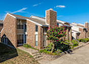 Thumbnail 2 of 46 - A row of brick apartment buildings with a tree in front.