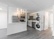 Thumbnail 46 of 48 - A kitchen with white appliances and a grey floor.