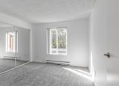 Thumbnail 42 of 48 - A white room with a door, window, and a mirror.