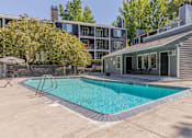 Thumbnail 2 of 48 - A swimming pool in a backyard with a house in the background.