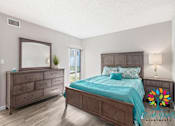 Thumbnail 2 of 2 - A bedroom with a bed, dresser, and mirror.