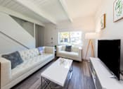 Thumbnail 24 of 29 - a living room with white couches and a white coffee table