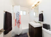 Thumbnail 23 of 29 - a bathroom with a white sink and a shower with a shower curtain