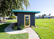 Thumbnail 15 of 29 - a small black building with a glass door and a green roof