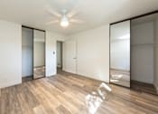 Thumbnail 4 of 29 - a bedroom with white walls and a ceiling fan