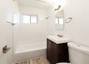 Thumbnail 12 of 29 - a bathroom with white walls and a white toilet next to a white sink and bathtub