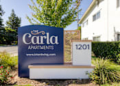 Thumbnail 1 of 17 - a sign in front of a house that says the carla apartments