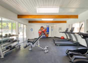 Thumbnail 12 of 15 - a home gym with exercise equipment and a mural of a hockey player on the wall