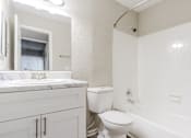Thumbnail 10 of 25 - A white bathroom with a toilet, sink, and bathtub.