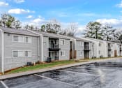 Thumbnail 9 of 25 - A row of townhouses with a parking lot in front.