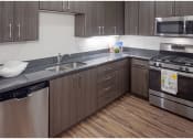 Thumbnail 8 of 23 - a kitchen with gray countertops and stainless steel appliances