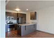 Thumbnail 7 of 23 - a kitchen with a large island and stainless steel appliances
