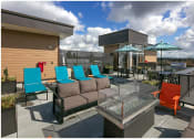 Thumbnail 21 of 23 - a patio with blue chairs and orange chairs and umbrellas