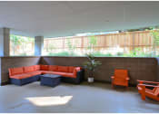 Thumbnail 22 of 23 - a lounge area with orange chairs and a couch