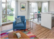 Thumbnail 12 of 23 - a living room with a blue chair and a colorful rug