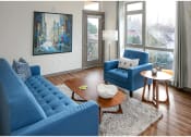 Thumbnail 11 of 23 - a living room with blue furniture and a large painting on the wall