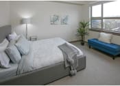 Thumbnail 14 of 23 - a bedroom with a large bed and a blue chaise lounge