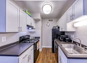 Thumbnail 26 of 31 - a kitchen with white cabinets and black appliances