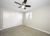 Thumbnail 12 of 22 - a bedroom with a ceiling fan and two closets