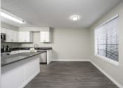 Thumbnail 9 of 22 - a kitchen with white cabinets and a large window
