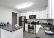 Thumbnail 7 of 22 - a kitchen with white cabinets and stainless steel appliances