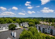 Thumbnail 18 of 22 - an aerial view of a neighborhood with green trees and a blue sky