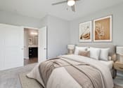 Thumbnail 7 of 15 - A bedroom with a large bed and two framed pictures on the wall.