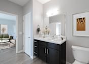 Thumbnail 10 of 15 - A bathroom with a white toilet and a white sink.