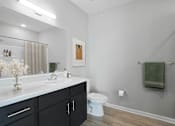 Thumbnail 8 of 15 - A bathroom with a white toilet and a white sink.