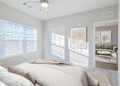Thumbnail 5 of 15 - A bedroom with a large bed and a window with blinds.