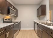 Thumbnail 11 of 24 - A kitchen with brown cabinets and a white counter top.