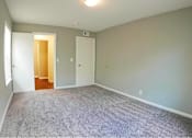 Thumbnail 15 of 24 - A room with a carpeted floor and two doors.