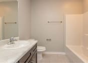 Thumbnail 17 of 24 - A white sink is on a countertop in a bathroom.