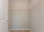 Thumbnail 20 of 24 - A white closet with a white door and a white shelf.