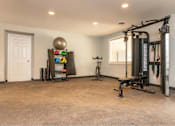 Thumbnail 23 of 24 - A spacious home gym with a variety of exercise equipment.