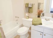 Thumbnail 8 of 24 - A white toilet sits next to a white sink in a bathroom.