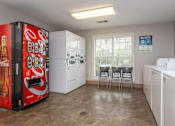 Thumbnail 20 of 27 - A Coca-Cola vending machine sits in a kitchen with white appliances and a window.