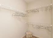 Thumbnail 12 of 27 - A white closet with two racks of hangers.