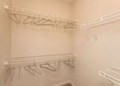 Thumbnail 14 of 27 - Empty white shelves with clothes hangers.