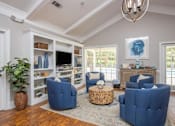 Thumbnail 17 of 27 - A living room with blue chairs and a wooden floor.